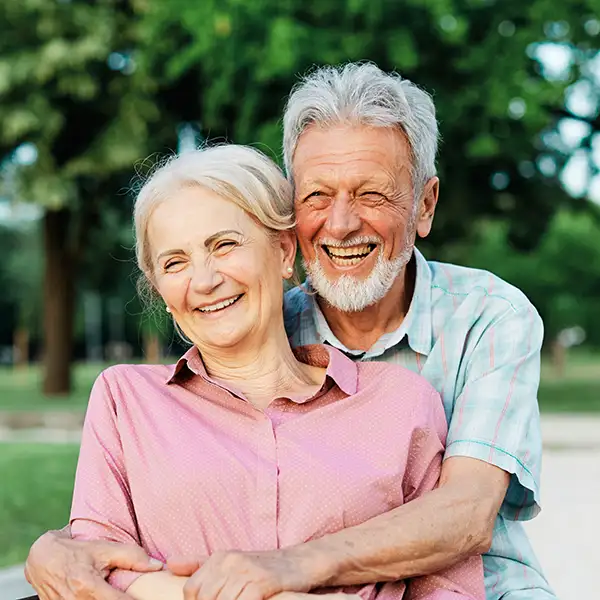 Elderly couple hugging and smiling outside