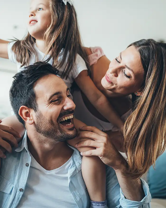 Smiling family of three in living room