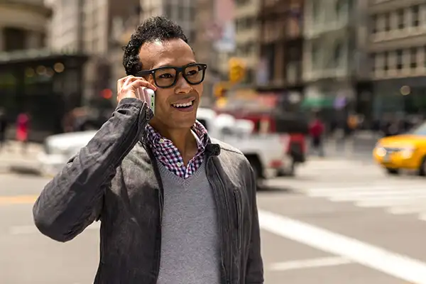 Young man standing outside using his phone to call